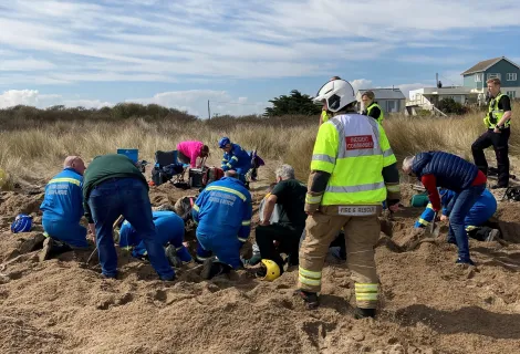 Rescuers digging out Warren Gant on the beach at Anderby Creek, Lincolnshire
