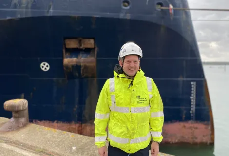 A picture of Survey and Inspection Technical Manager (Southampton) Chris D'Alcorn, stood in front of a vessel in S&I kit - Maritime Safety Week 2023