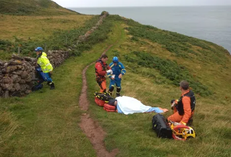Coastguards supporting Margaret Albery on the clifftop