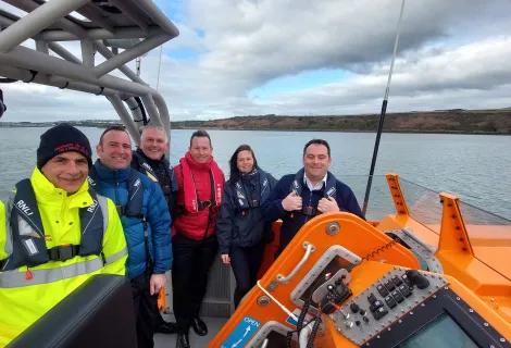 Deputy to the SOSREP Lisa McAuliffe standing with coastguard colleagues onboard a vessel
