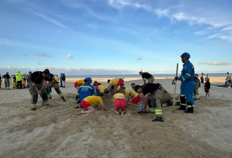 Firefighters, lifeguards and Coastguard Rescue Officers practice a sand hole rescue
