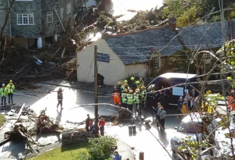 Emergency service personnel in Boscastle stand near damaged buildings
