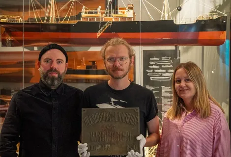 From left are Curators Jannik Hartrup and Curator Thorbjorn Thaarup, and Museum Assistant Mette Ebbesen in front of a model of the SS Viola, sister ship to the SS Birgitte