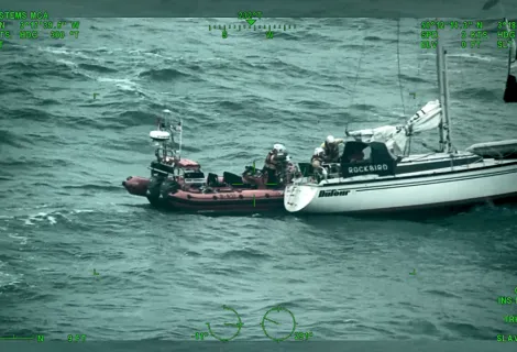 An RNLI lifeboat rescuing Richard Spreckley from his vessel during rough sea conditions