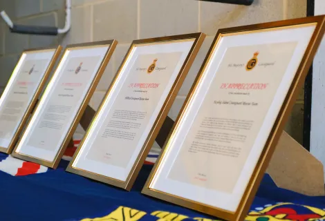 Framed awards of recognition lined up on a table