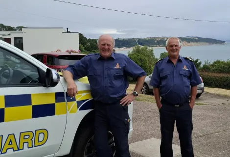 Roger and Terry posing in front of a HM Coastguard vehicle in 2025. 
