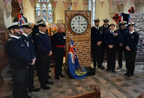 Coastguards stand either side of the memorial clock at St Nicholas Withernsea
