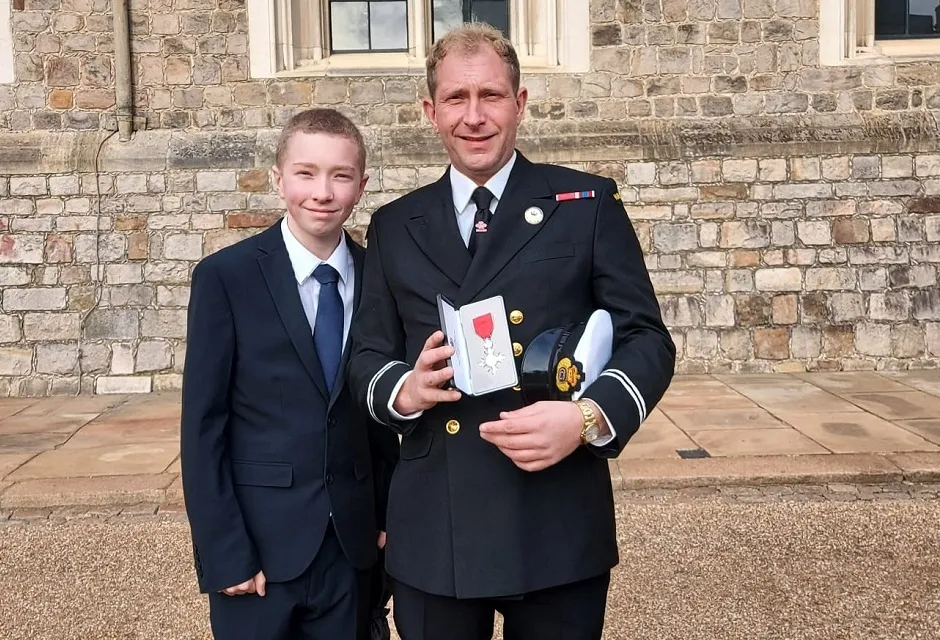 Daniel Thomson received his MBE supported by 12 year-old son Jacob