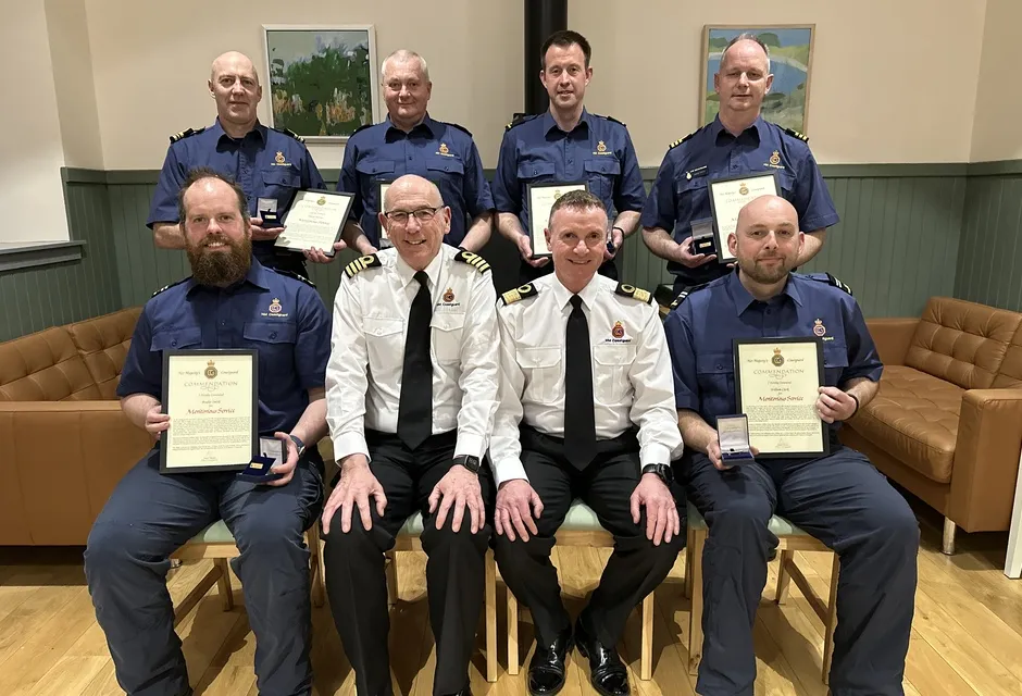 Coastguard team members holding their commendation awards