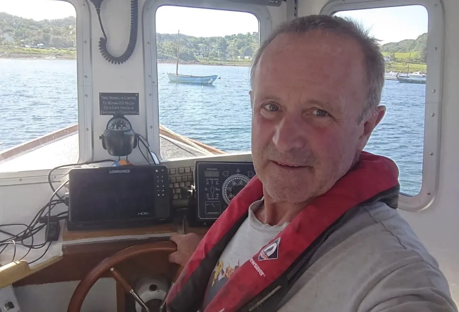 Hans Unkles behind the wheel of his electric fishing vessel, Lorna Jane
