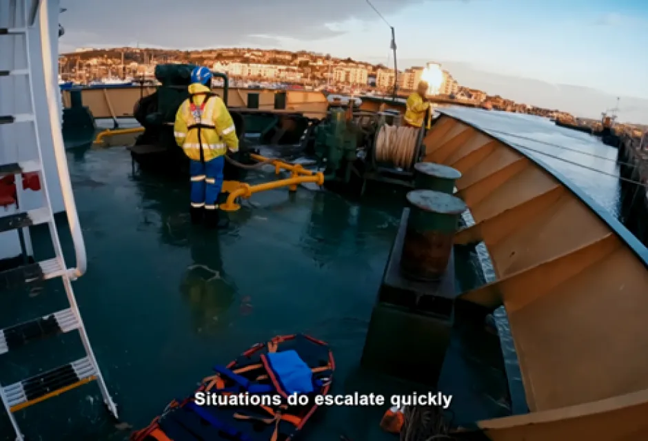 Coastguard officer stood at front of large vessel