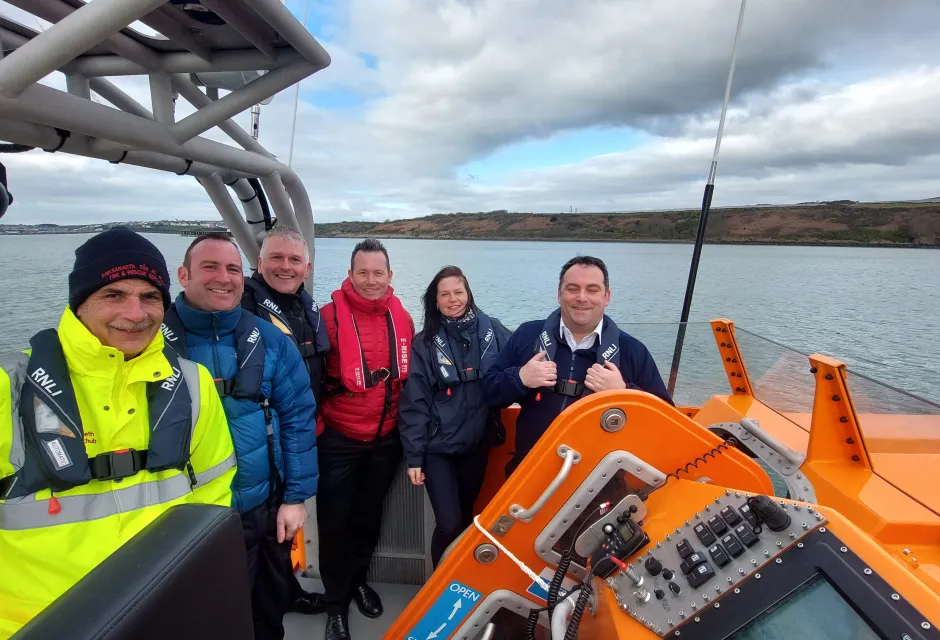 Deputy to the SOSREP Lisa McAuliffe standing with coastguard colleagues onboard a vessel