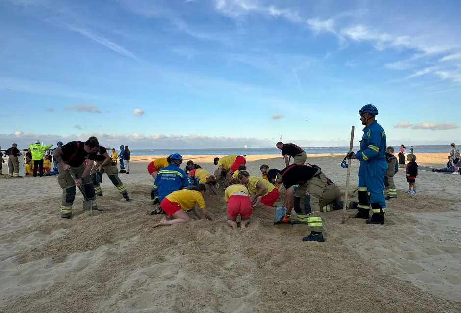 Firefighters, lifeguards and Coastguard Rescue Officers practice a sand hole rescue