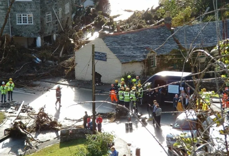 Emergency service personnel in Boscastle stand near damaged buildings