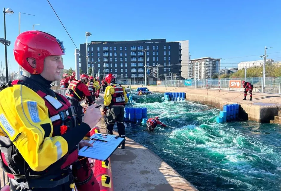 A coastguard wearing a dry suit watches a flood exercise