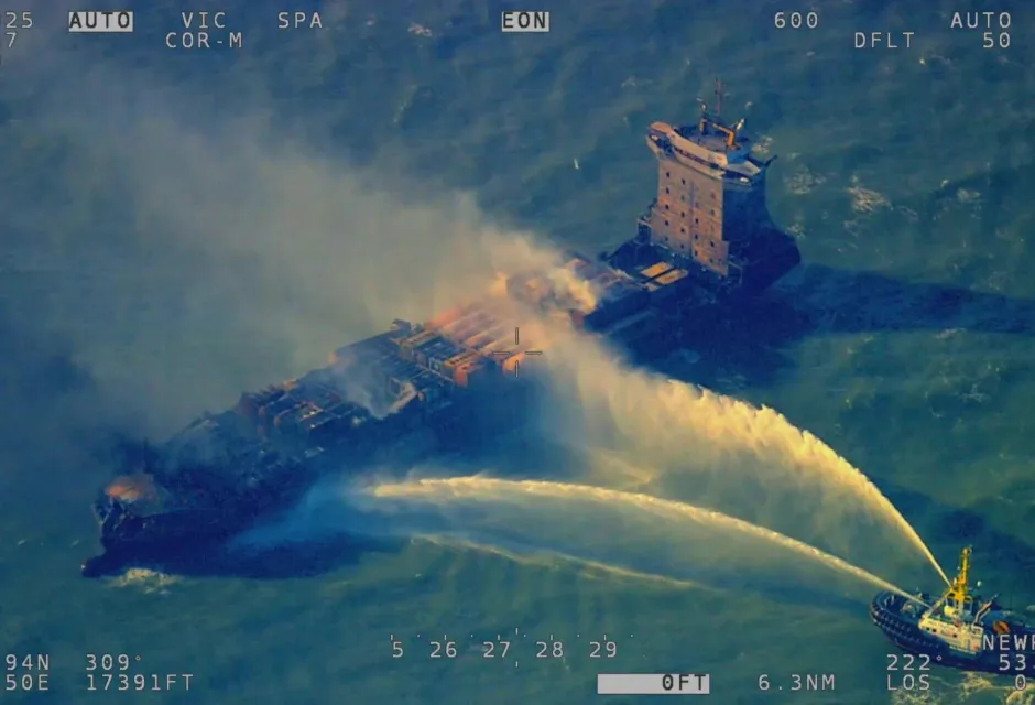 An aerial view of the SOLONG vessel with water being poured over it from a tug