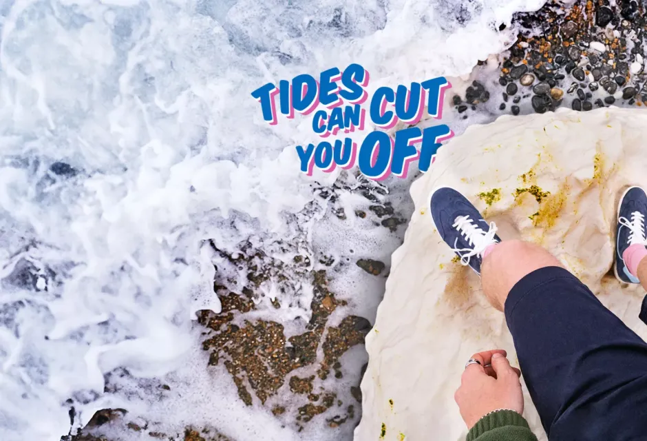 Coast Clever campaign imagery; two feet stand on a rock ledge above rapidly rising tidal waters. Text states: "Tides can cut you off". 