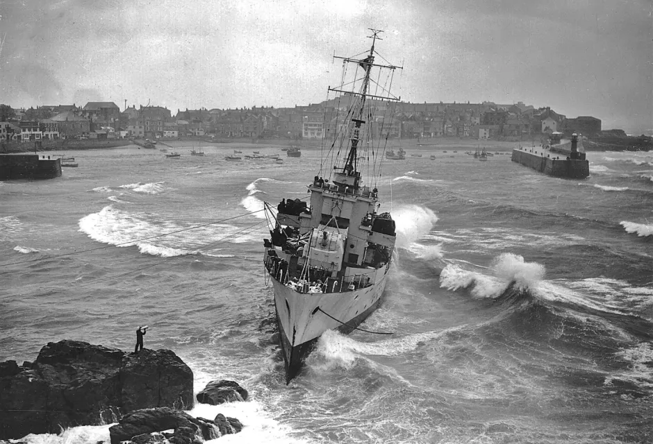 Coastguard Harry Barlow speaks with the captain of HMS Wave at St Ives