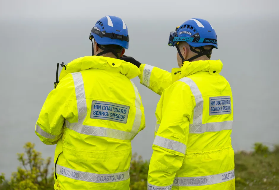Stock image of two coastguard rescue officers looking out to sea